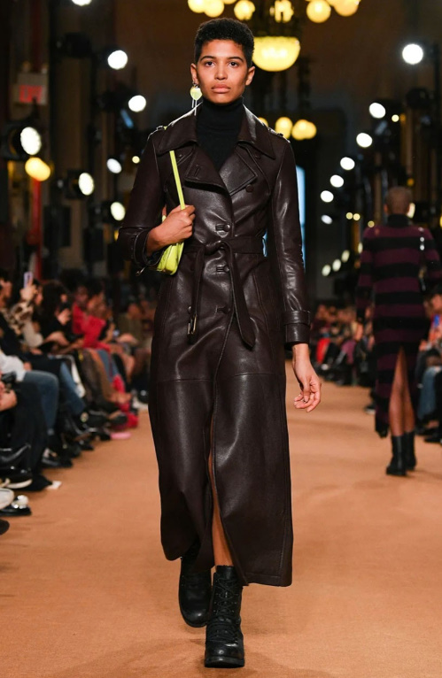 블랙 컬러의 이너에 브라운 컬러 레더 코트를 입은 여자 모델의 모습이다.
포인트로 형광 컬러의 숄더백을 매치했다.