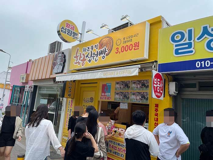 경주 황리단길에서 유명한 십원빵을 사기 위해 줄 서서 기다리는 사람들 모습이 보이는 사진