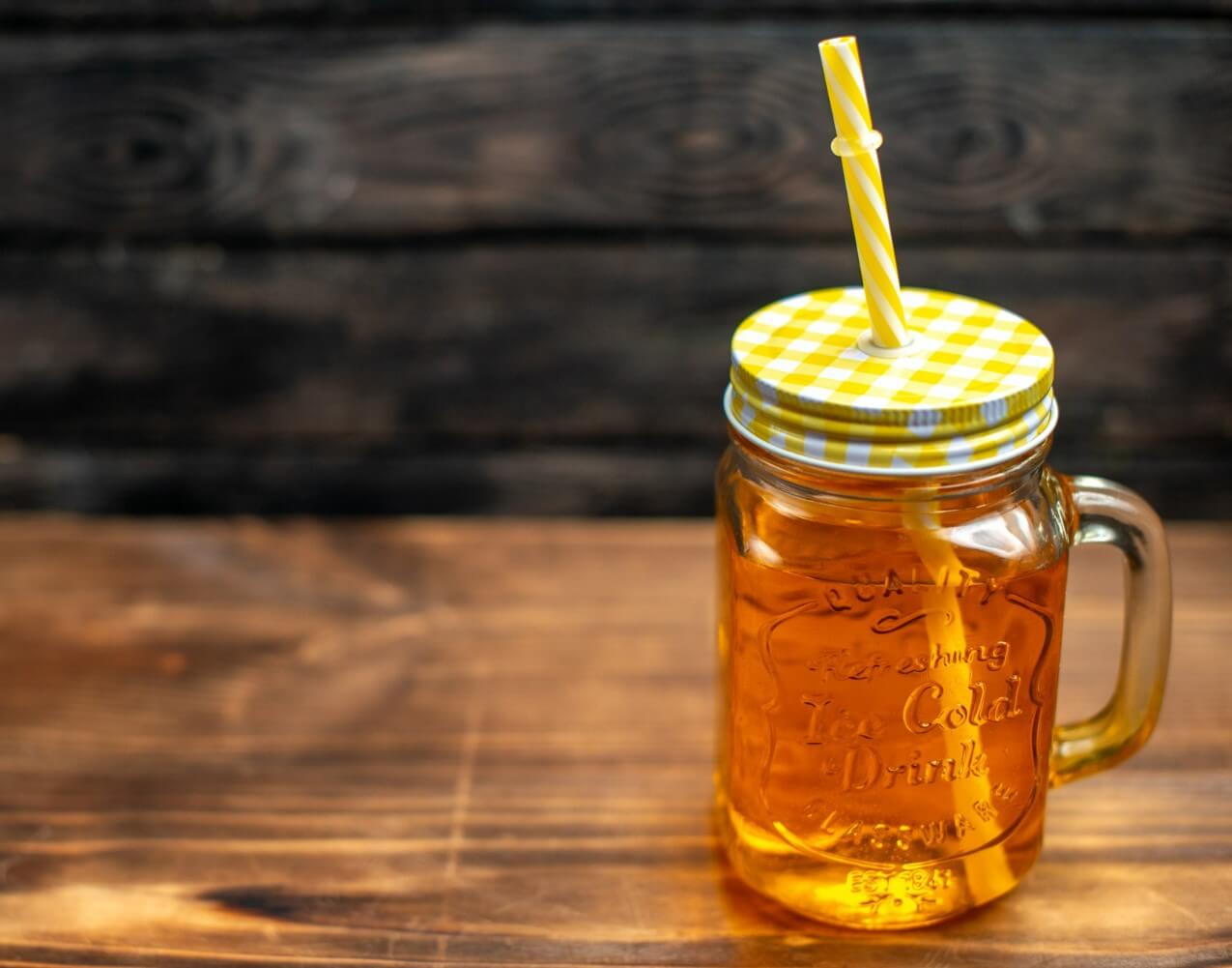 유리병에 꿀 음료수가 들어있고 빨대가 꽂혀있다.