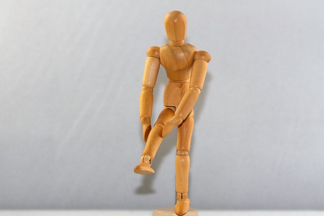이것은 무릎 통증을 느끼는 남성을 목각 인형으로 만든 사진입니다.