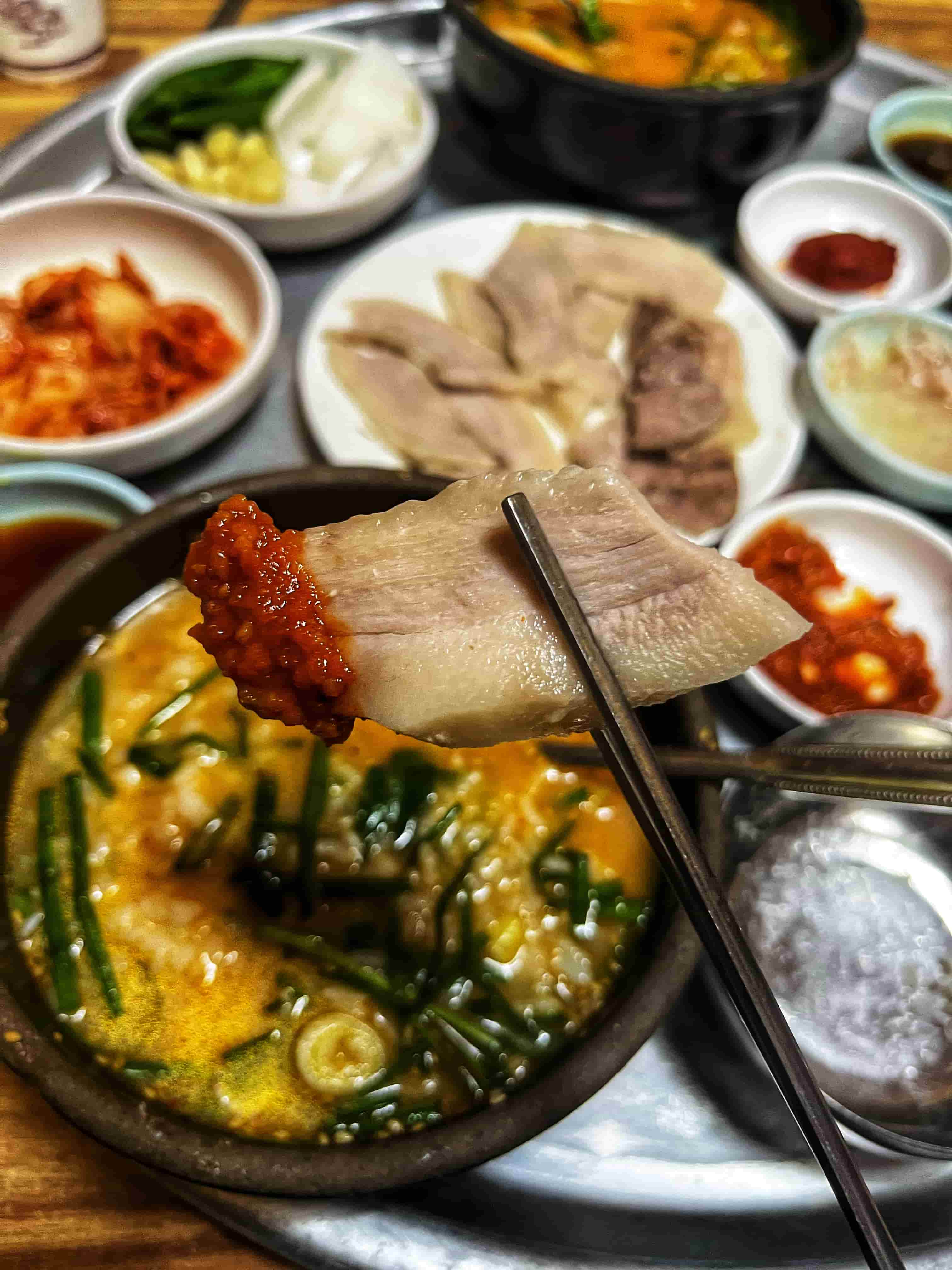 수육을 쌈장에 찍어 먹는 사진