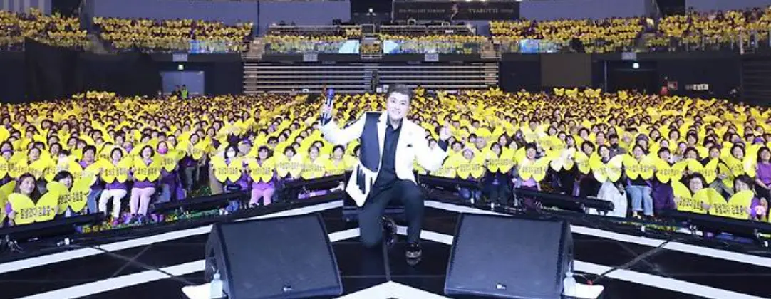 콘서트 현장 노란옷을 입은 팬들과 그앞에서 함께 사진찍는 김호중