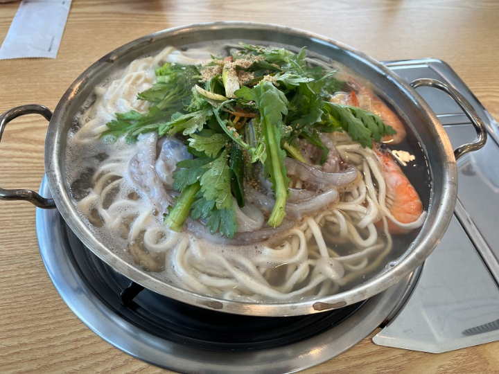 손잡이-달린-은색-냄비에-담긴-채소와-해물