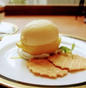 반으로 잘려진 레몬이 버터와플같은 과자와 함께 접시위에 올려져 있다.