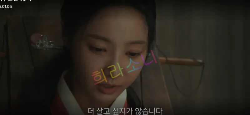 미령이 감정에 젖은 얼굴로 바닥을 바라보며 슬픈 표정을 짓고 있습니다. 자막은 &amp;quot;더 살고 싶지가 않습니다.&amp;quot;