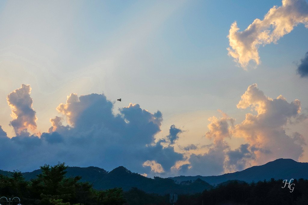 해 질 녘 구름 배경으로 날아가는 배드민턴