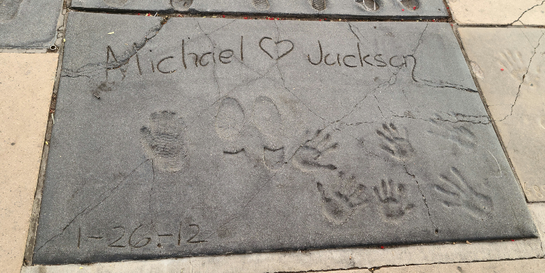 마이클 잭슨의 손&#44; 발이 찍힌 돌판. 마이클 잭슨의 이름이 손글씨로 적혀 있고&#44; 7개의 손 모양과&#44; 두 구두 발자국이 찍혀 있다.
