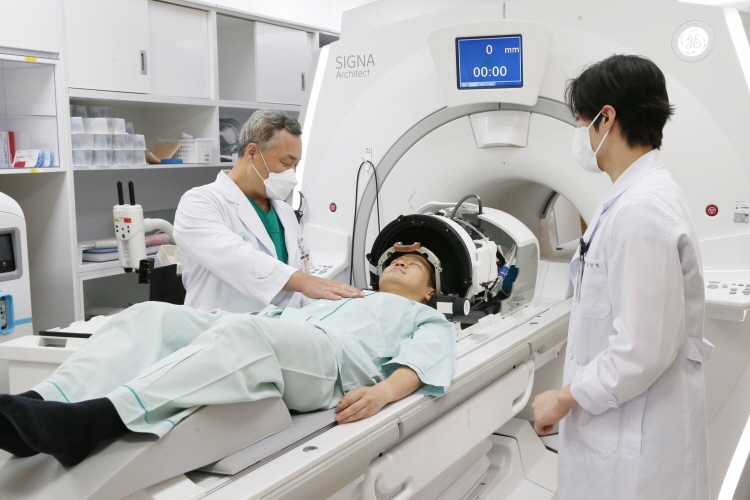 서울아산병원 전상용 신경외과 교수(좌측)가 수전증 환자에게 초음파 뇌수술에 대해 설명하고 있다(사진제공=서울아산병원)