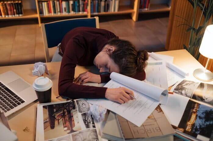 서류들이 어지럽게 펼쳐져 있는 책상 위에 피곤한 듯 엎드려 잠고 있는 한 여자