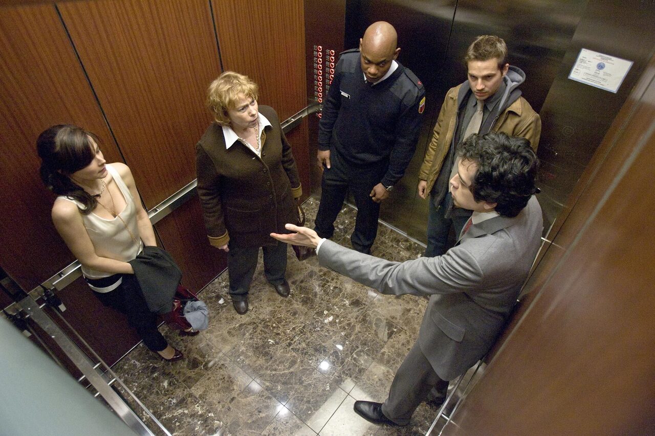 엘리베이터에 갇힌 5명의 사람들의 모습&#44; 영화 데블의 한 장면