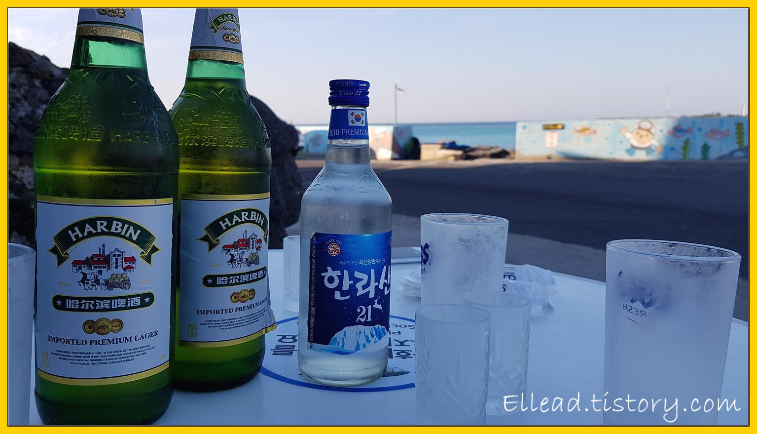 맥주&#44; 소주가 놓인 바닷가 테이블...