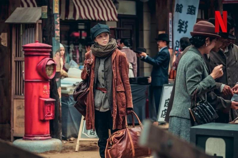 1945년 거리를 배경으로 거리에 서 있는 넷플릭스 경성크리처에서 윤채옥을 연기하는 배우 한소희