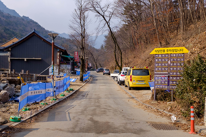 계룡산 동학사 코스 들머리. 왼쪽으로는 식당이 있고, 오른쪽으로는 언덕 아래에 자동차들이 주차해있다.