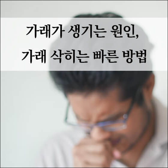 기침을 참으며 손으로 입을 가리고 있는 남성