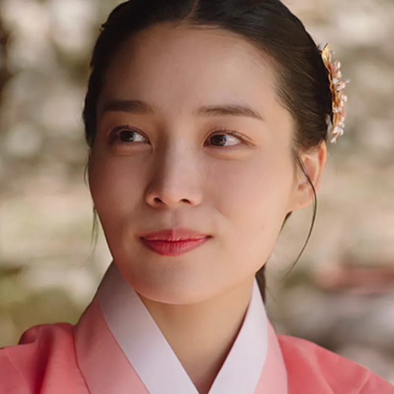 조선시대 야외를 배경으로 분홍색 한복을 입고 미소 짓는 윤해선