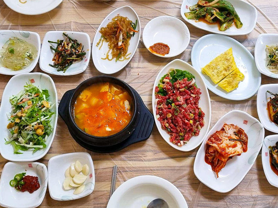 육회 가마솥집밥과 숭늉이 테이블에 차려진 사진