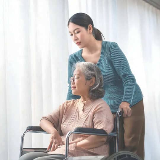 Caregiver-helping-senior-woman-in-wheelchair