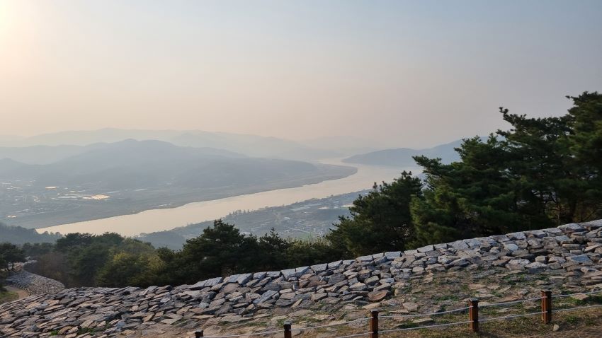 성곽 따라 내려가는 성곽 돌길, 흐린 하늘, 가운데 흐리게 보이는 남한강,