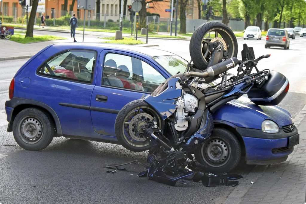 오토바이가 자동차와 부딪혀 사고가 났다.