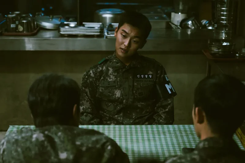 어느 군 식당을 배경으로 군복을 입은 채 테이블에 앉아 있는 신아휘