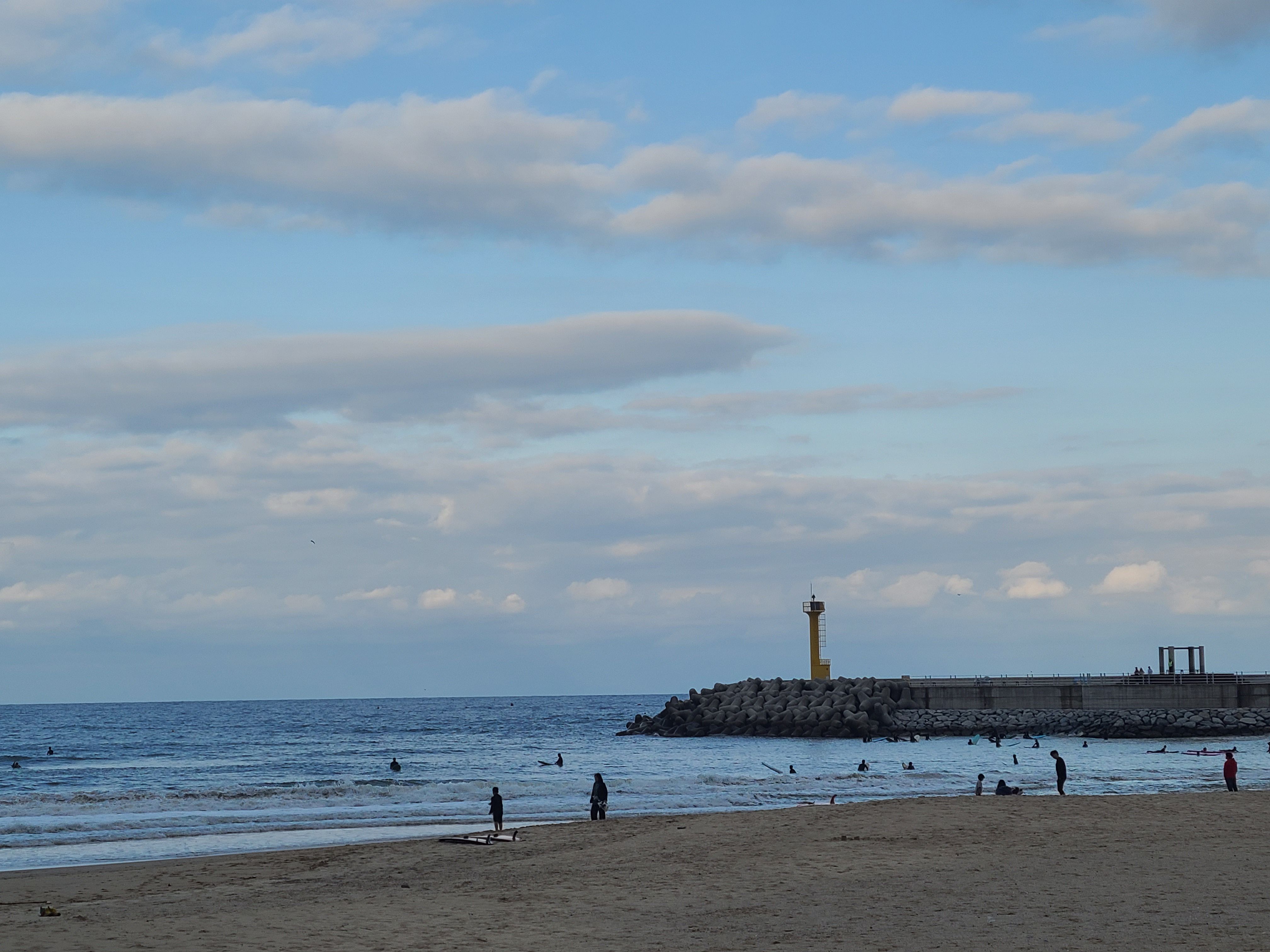 방파제와 등대가 있는 해변 모습