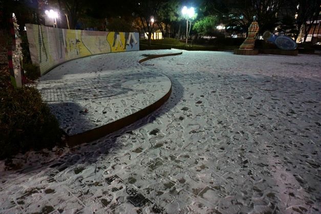 공원 보안등에 환한 불빛&#44; 테마공원 바닥에 엷게 쌓인 눈&#44;