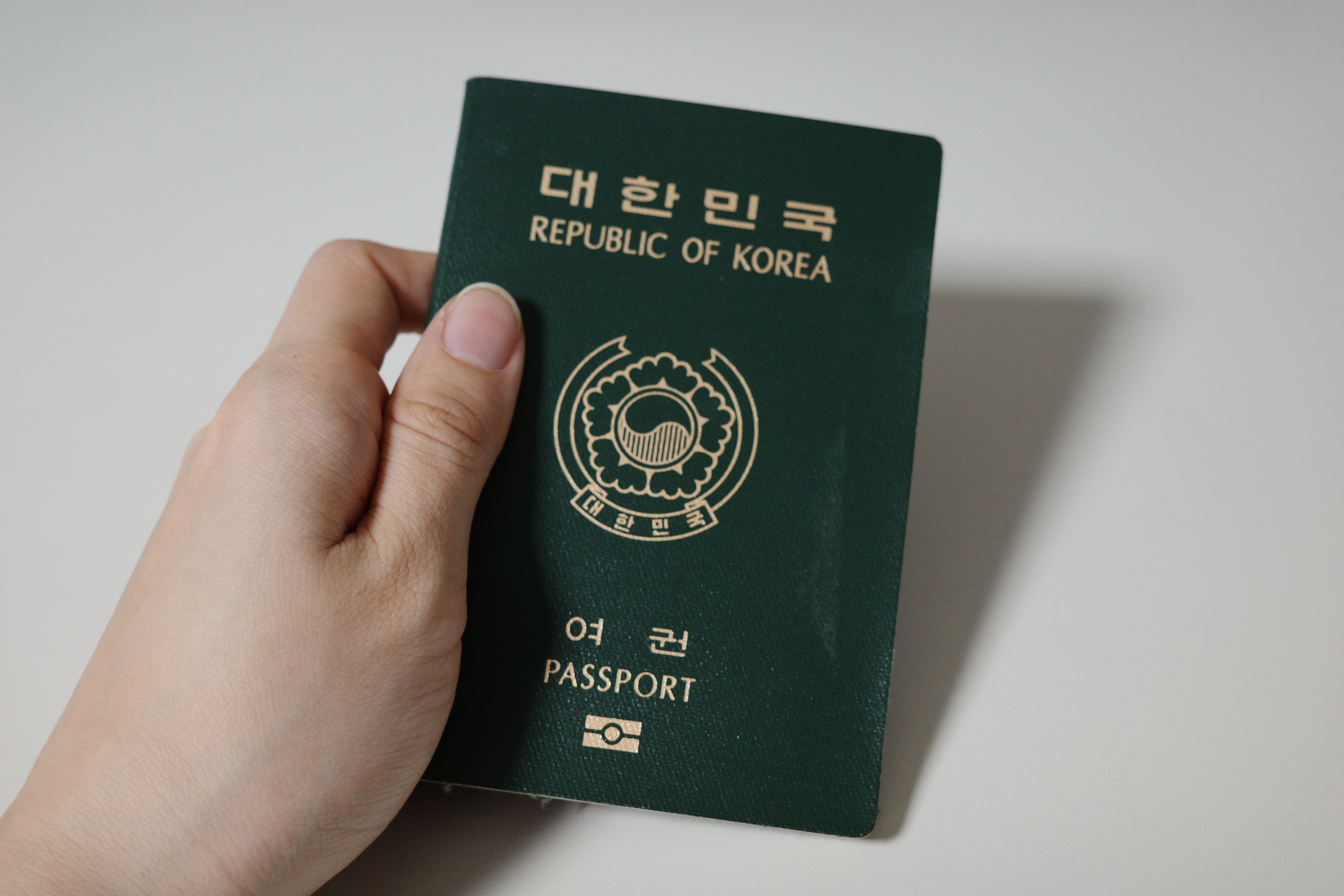 녹색 여권을 손에 쥐고 있는 모습