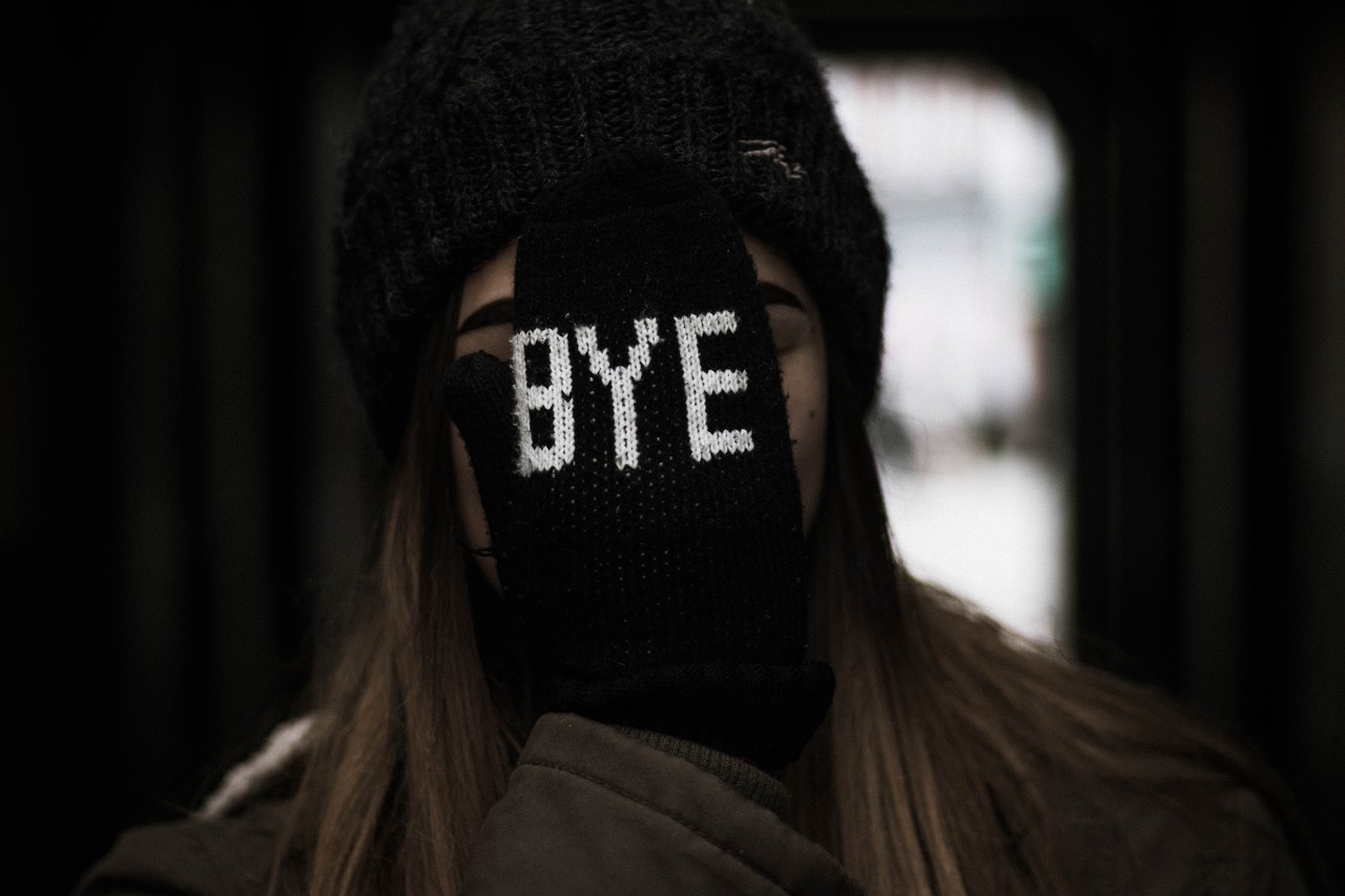 여성이 'bye'라고 씌여진 장갑을 끼고 있다.
