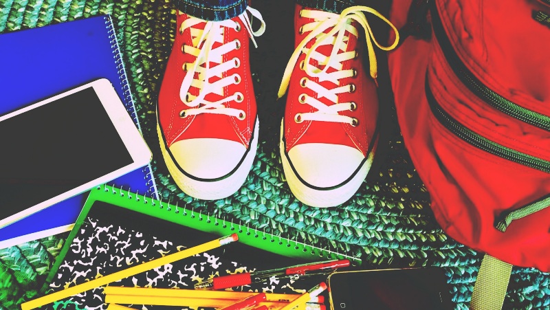 A top-down view of a student's backpack, notebooks, phone, and pencils prepared for emergencies during study abroad in the U.S.