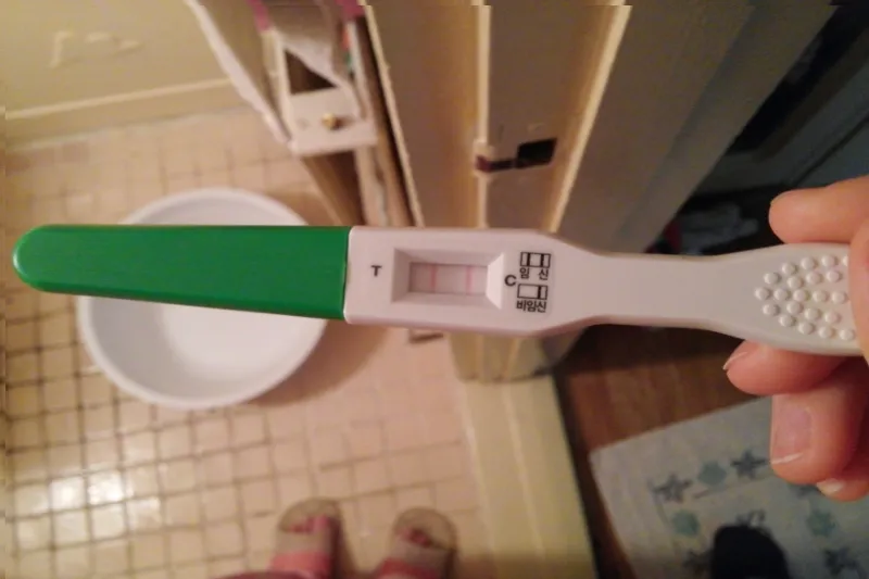 임신테스트기를 검사하는 장면을 보여주는 사진입니다.