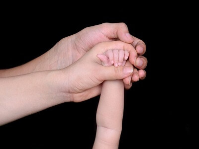 신생아의 손과 부모님의 손