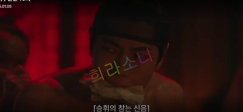붉은 조명 아래 상의를 벗은 승휘가 긴장된 표정으로 옆을 응시하고 있습니다. 머리에는 전통 관모를 쓰고 있으며&amp;#44; 입 주변에는 하얀 천이 감싸져 있습니다. 자막은 &amp;quot;[승휘의 참는 신음]&amp;quot;.