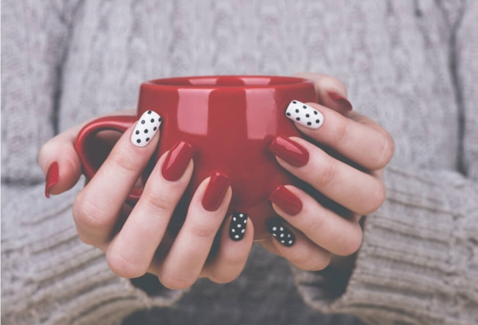 빨간색&#44; 하얀색&#44; 검정색 등 다양한 네일아트를 한 손으로 컵을 들고 있다