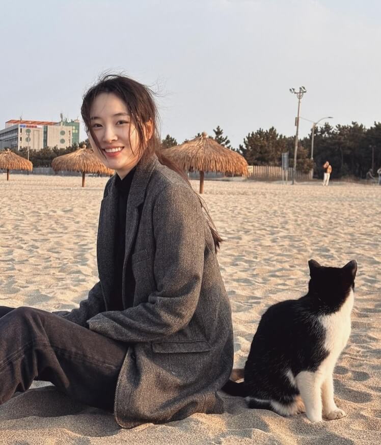 모래사장에앉아있는-여성과고양이의모습