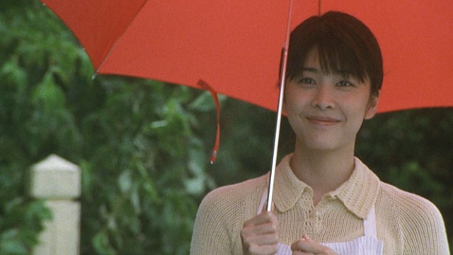 영화 &lt;지금&#44; 만나러 갑니다&gt; 스틸 이미지&#44; 아내 미오가 우산을 쓰고 미소짓는 모습