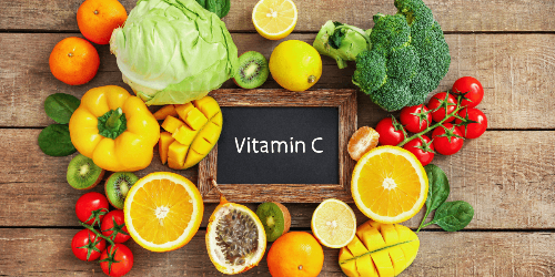 까만보드에 Vitamin C가 적혀있고&#44; 주위에 비타민 C가 놓여져 있다.