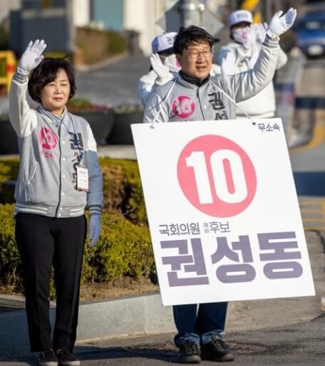 아내와 함께 무소속 10번 팻말을 메고 선거운동 하며 손을 흔드는 모습