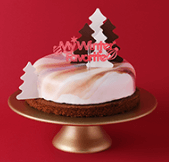 흰 생크림 케이크 위 크리스마스 나무 과자가 3개 얹어진 이미지