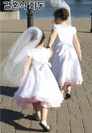 결혼식 화동으로 두 아이가 드레스를 입고 있음