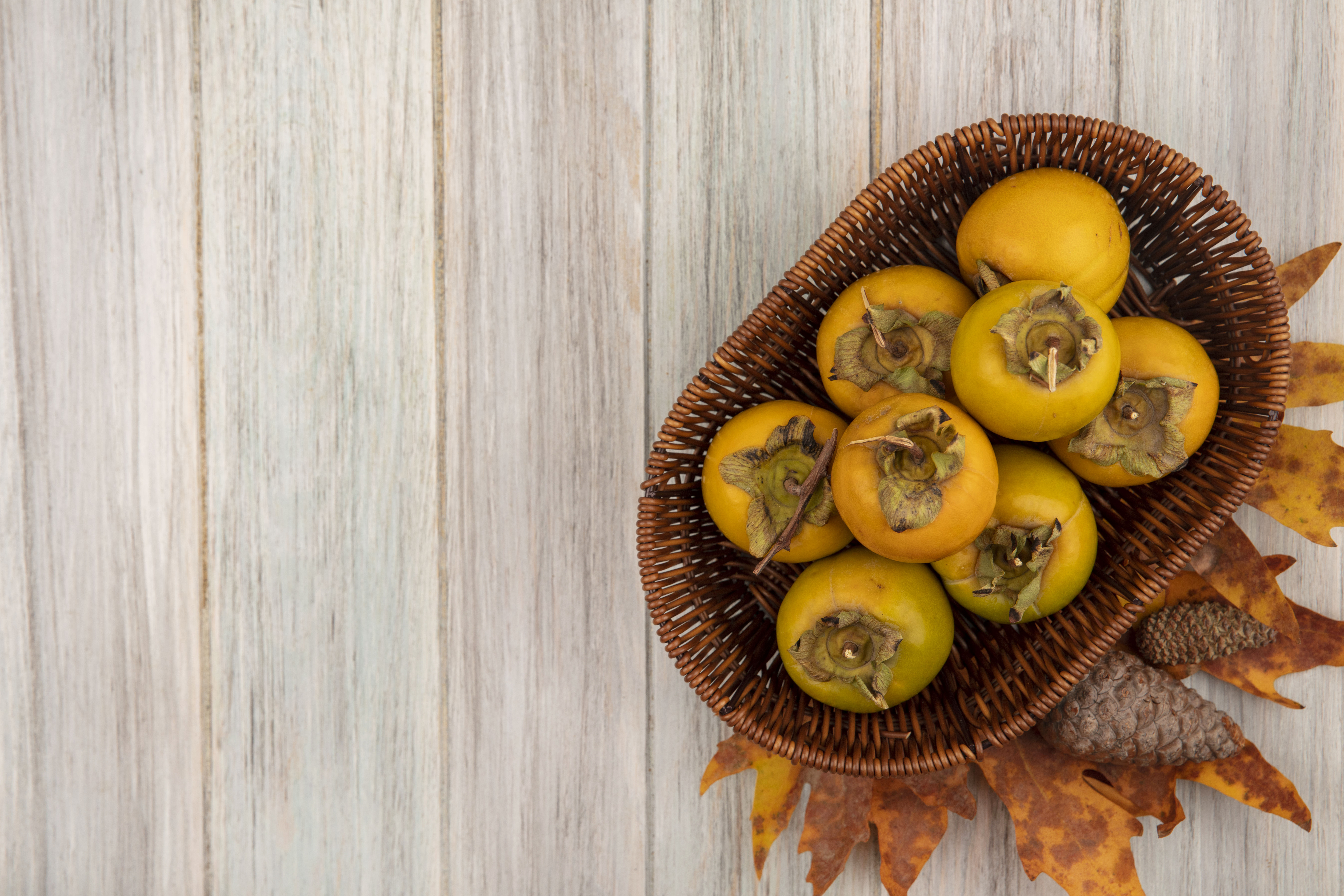 top-view-persimmon-fruits-bucket-grey-wooden-table-with-copy-space top-view-persimmon-fruits-bucket-on-grey-wooden-table-with-copy-space