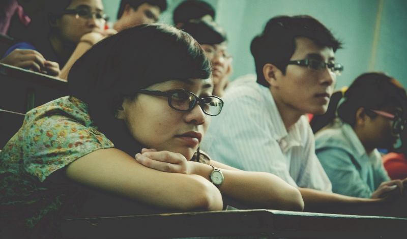 Group of students seated with serious expressions, symbolizing academic evaluation and competition