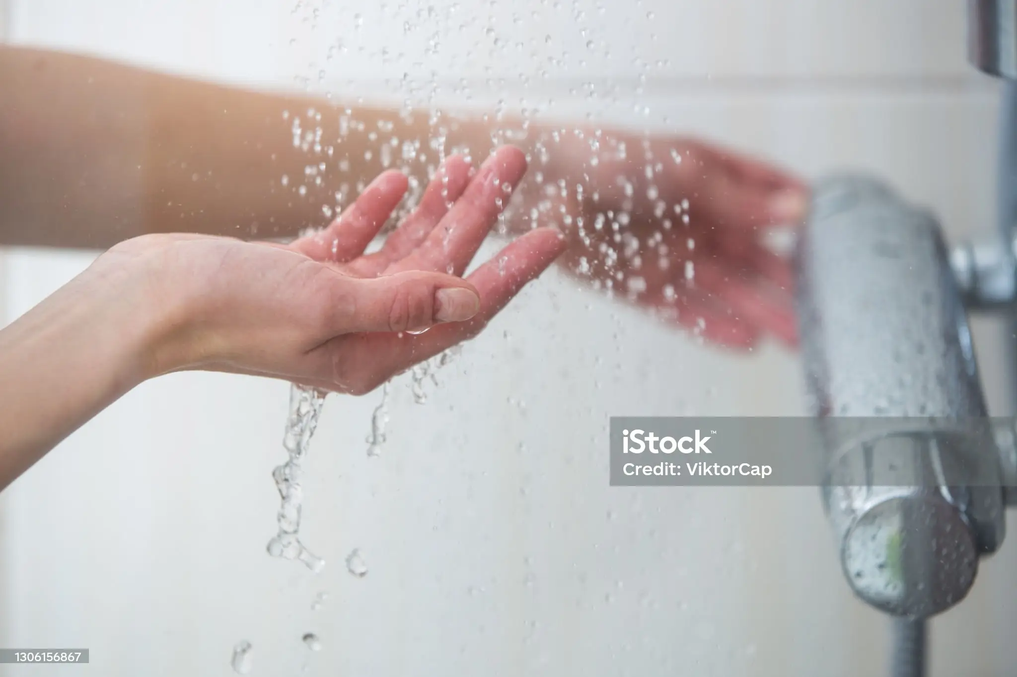 샤워기를 왼손으로 틀고 오른손으로 떨어지는 물을 받는 사람의 손