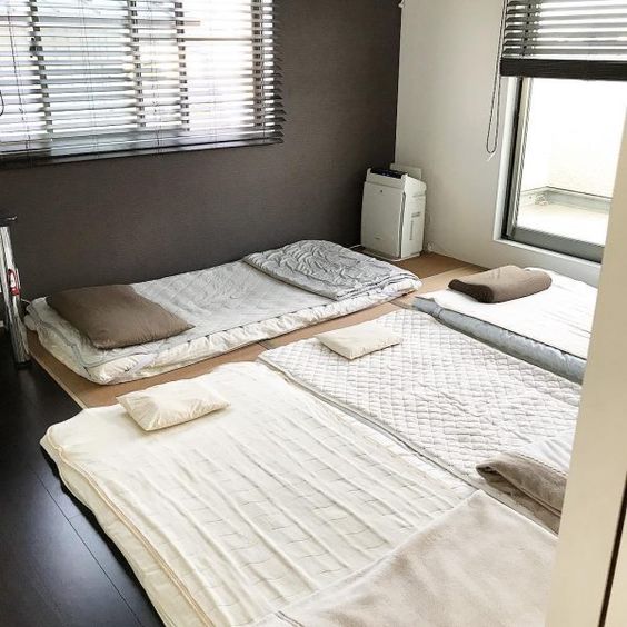 알파벳 E 자 형으로 침구 4세트가 깔린 방 사진