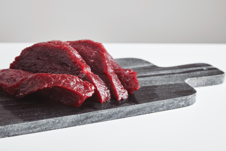 sliced-premium-raw-whale-meat-steak-marble-stone-cutting-board-isolated-white-table-900