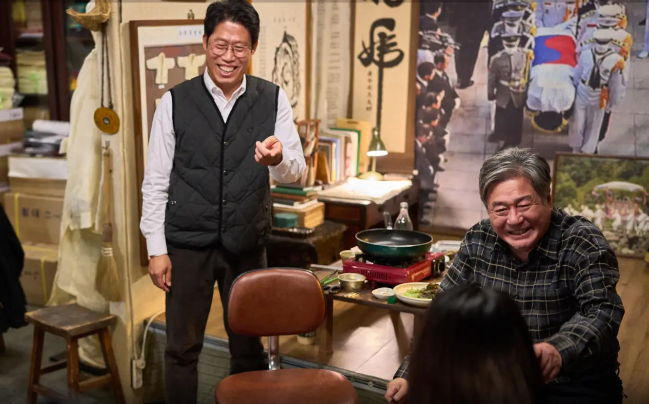 파묘- 유해진의 장의사 가게안 웃으며 서있는 유해진과 웃으며 앉아있는 최민식 맞은편 앉아 있는 김고은 뒷모습