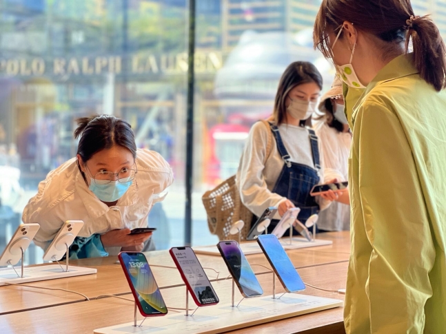 중국 베이징에 있는 애플 스토어에서 소비자들이 아이폰을 살펴보고 있다.