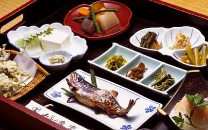 작은 생선과 나물등이 테이블 위에 올라가 있다.