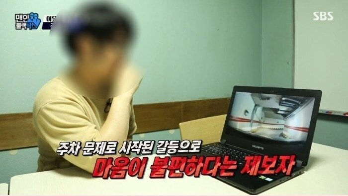  주차장 출입구 일부를 막고 정차 중인 차