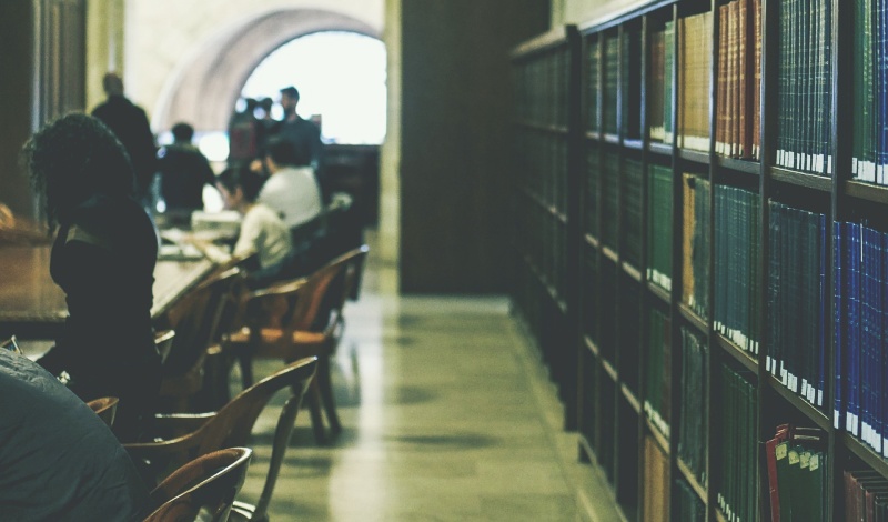 A study area in a university library with students reading and working, symbolizing academic continuation after military service.