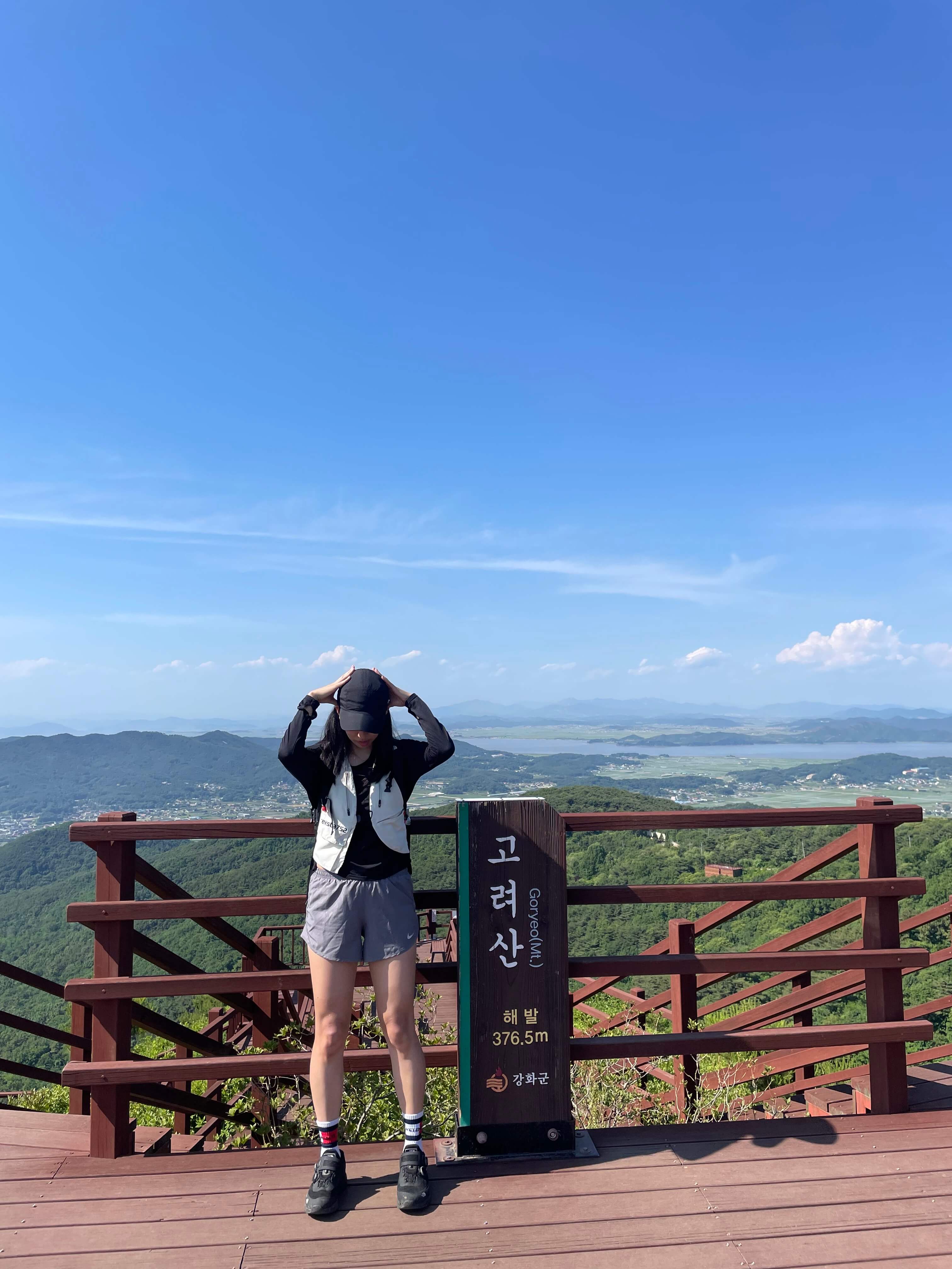 고려산 정상석 인증샷모습 정상석 앞에서 서서 인증을 하는 모습 하늘은 맑고 깨끗하며 더운 날씨모습